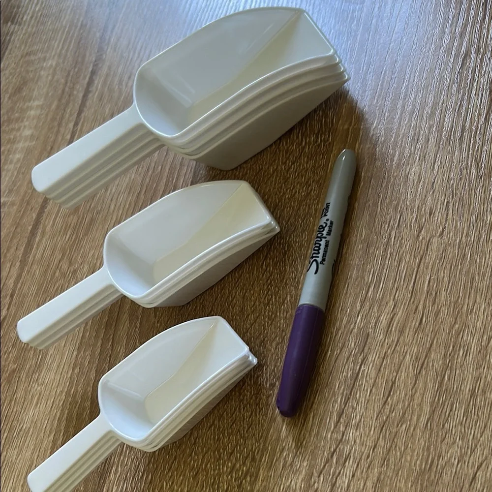 Stack of White Plastic Scoops - 11 pieces